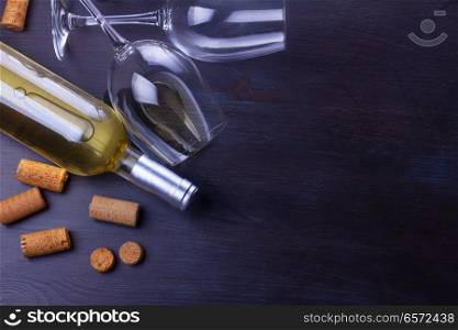 Bottle of white wine and two wine glasse on table, flat lay scene. Glass of red wine