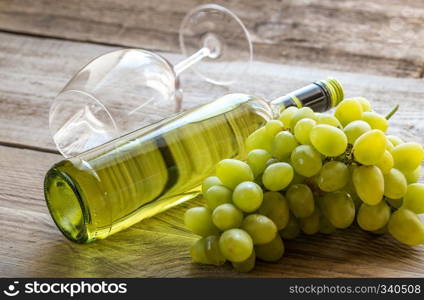 Bottle of white wine with bunch of grape