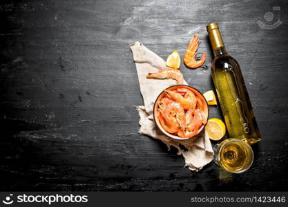 bottle of white wine with shrimp and lemon. On the black chalkboard.. bottle of white wine with shrimp and lemon.