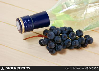 bottle of wine and a bunch of grapes on the table