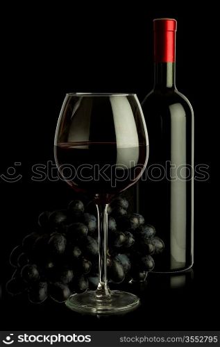 bottle of wine and grapes isolated on black background