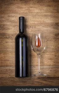 Bottle of wine with glass on wooden background