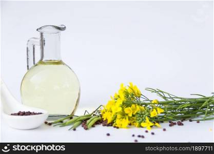 bottle rapeseed oil seeds and flowers on white background. canola oil, flowers and seeds isolated white background