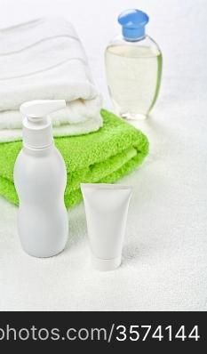Bottle tube and cotton towels on white background