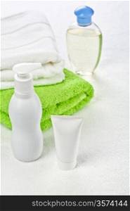 Bottle tube and cotton towels on white background