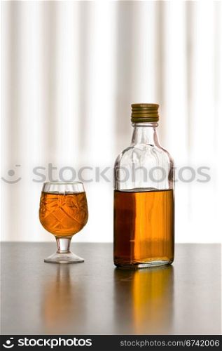 bottle whiskey and wineglass on the table