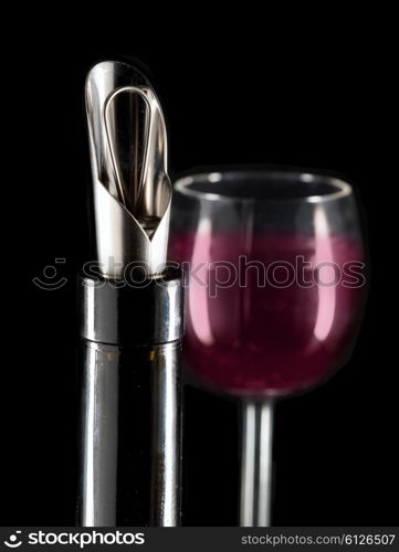 bottle with a special nozzle for wine pouring and a wine glass