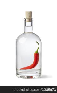 Bottle with chili pepper vinegar on white background