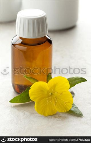 Bottle with Evening Primrose oil and fresh flower