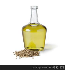 Bottle with hemp oil and unshelled hemp seed on white background
