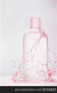 Bottle with lotion, tonic or micellar cleansing water , natural cosmetic product or beauty concept on pastel background, front view