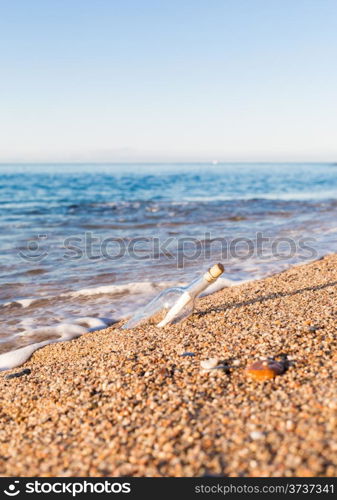 Bottle with message inside on the shore at the beach