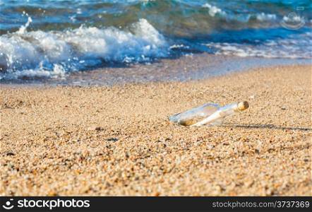 Bottle with message inside on the shore at the beach