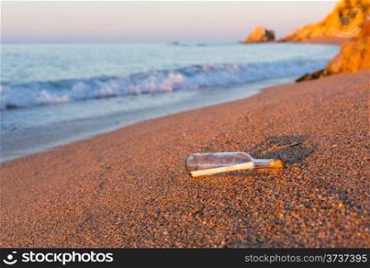 Bottle with message inside on the shore at the beach
