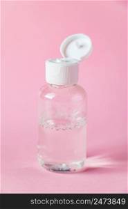 Bottle with micellar cleansing water on a pink background. Skin care concept.. Bottle with micellar cleansing water on pink background. Skin care concept.