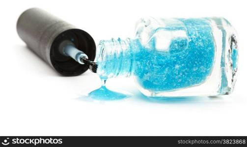 bottle with spilled blue nail polish on white background