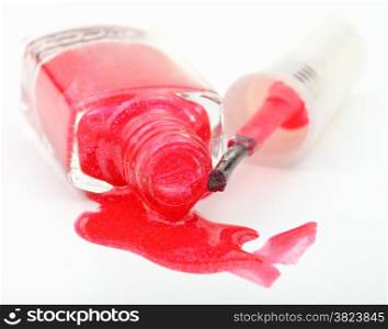 bottle with spilled red nail polish on white background