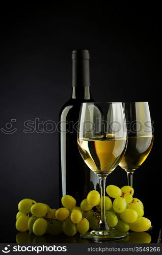 bottle with white wine and glass and grapes