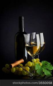bottle with white wine and glass and grapes