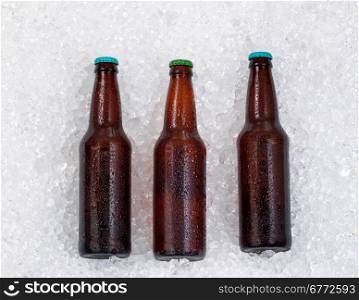 Bottles of beer, lying on side, cooling down on pile of ice.