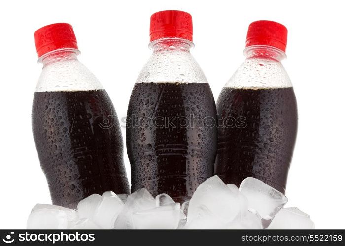 bottles of cola in ice on white background