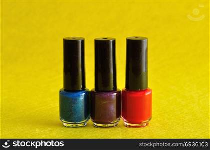 Bottles of colorful nail polish displayed against a yellow background