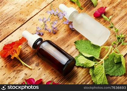 Bottles of essential oil with fresh herbs and flowers.Natural herbal medicine. Essential oils with herbs and flowers