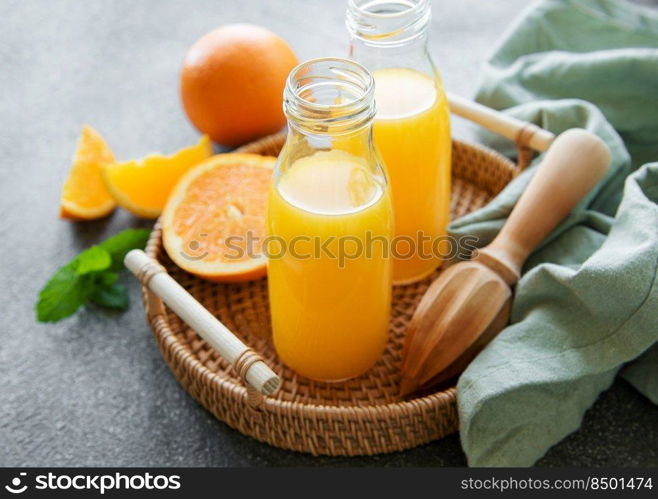 Bottles of fresh orange juice with fresh fruits