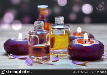 bottles of oil and candle on white bokeh background