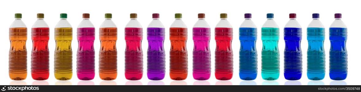 Bottles of oil of different colors lined up on a white background