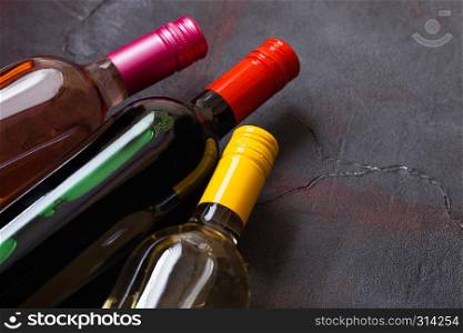 Bottles of red white and pink rose wine on stone kitchen table background. Top view