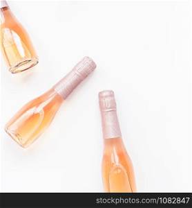 Bottles of rose champagne wine in minimal composition isolated on white background with copy space. Natural light. Template for tasting, degustation invitation card. Top view. Flat lay