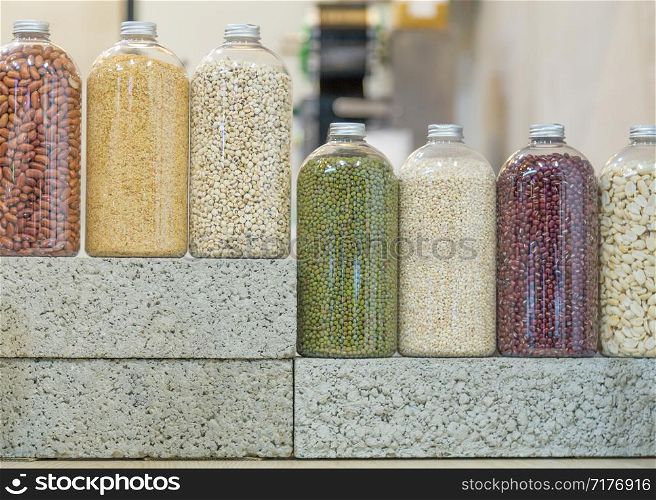 Bottles of seeds and legumes on bricks