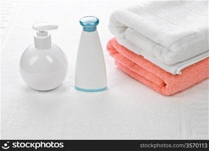 bottles with cotton towels on white background