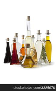 Bottles with various types of oil and vinegar on white background