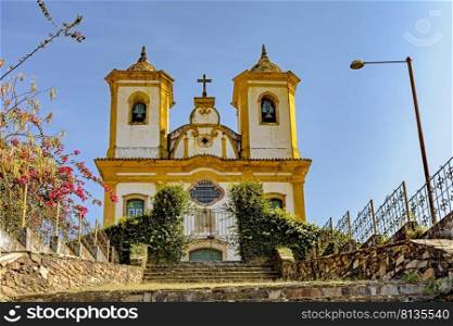 Bottom view of ancient stairs and historic church of 18th century colonial architecture on top of the hill in the city of Ouro Preto in Minas Gerais, Brazil with the mountains behind. Bottom view of ancient stairs and historic church of 18th century colonial architecture