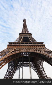 bottom view of Eiffel tower in Paris with white clouds on blue sky