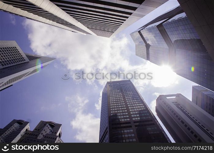 Bottom view of modern skyscrapers/office buildings in the business district of Singapore cities against the blue sky. Economy, finances, business activity concept.