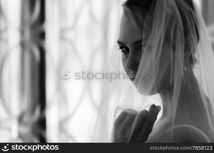 Boudoir, attractive young woman wearing lingerie and she stands front of the window - black and white image