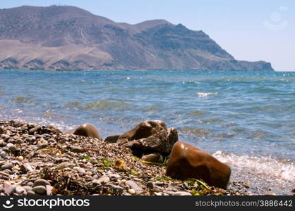 boulder on the coast is shooting close-up on a background of mountains