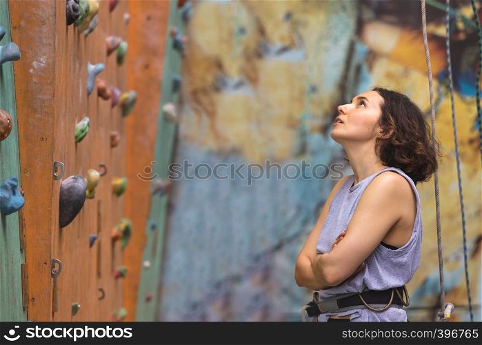 Bouldering, beautiful girl look on the climbing wall. Assessment of their capabilities.