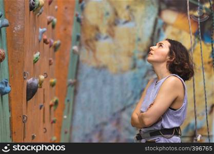 Bouldering, beautiful girl look on the climbing wall. Assessment of their capabilities.