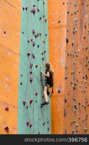 bouldering, little girl climbing up the wall