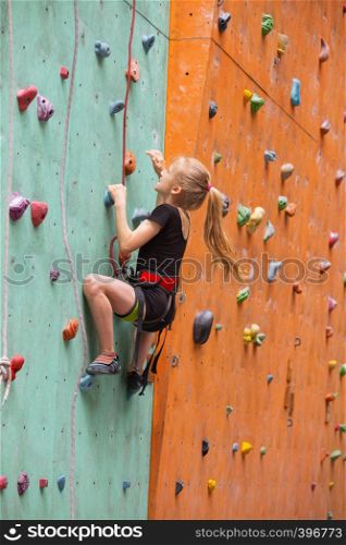 bouldering, little girl climbing up the wall