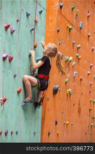 bouldering, little girl climbing up the wall