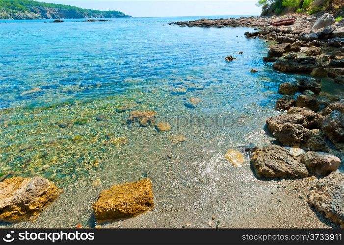 boulders on the shore of a clean and calm sea