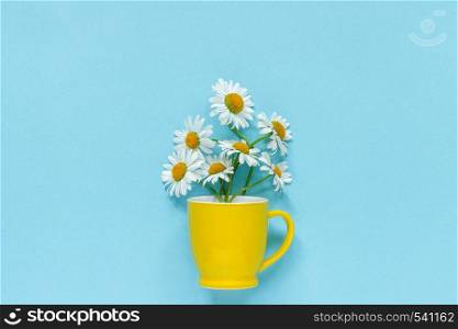 Bouquet chamomile daisies flowers in yellow mug on pastel blue color paper background Copy space Template for postcard, lettering, text or your design Flat lay Top view Concept Hello summer.. Bouquet chamomile daisies flowers in yellow mug on pastel blue color paper background Copy space Template for postcard, lettering, text or your design Flat lay Top view Concept Hello summer