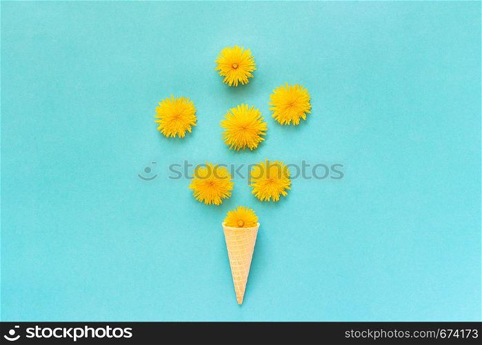 Bouquet dandelions flowers in waffle ice cream cone on blue background Copy space Creative Flat lay Top view.. Bouquet dandelions flowers in waffle ice cream cone on blue background Copy space Creative Flat lay Top view