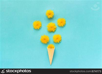 Bouquet dandelions flowers in waffle ice cream cone on blue background Copy space Creative Flat lay Top view.. Bouquet dandelions flowers in waffle ice cream cone on blue background Copy space Creative Flat lay Top view