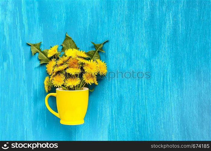 Bouquet dandelions taraxacum flowers in yellow mug on wood blue background Copy space Template for postcard, lettering, text or your design Flat lay Top view Concept Hello summer top-down composition.. Bouquet dandelions taraxacum flowers in yellow mug on wood blue background Copy space Template for postcard, lettering, text or your design Flat lay Top view Concept Hello summer top-down composition